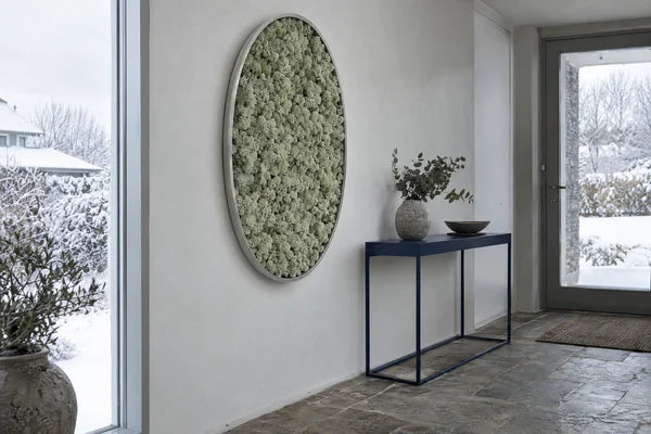 Quadro ovale in verde stabilizzato nell’ingresso minimal di una casa