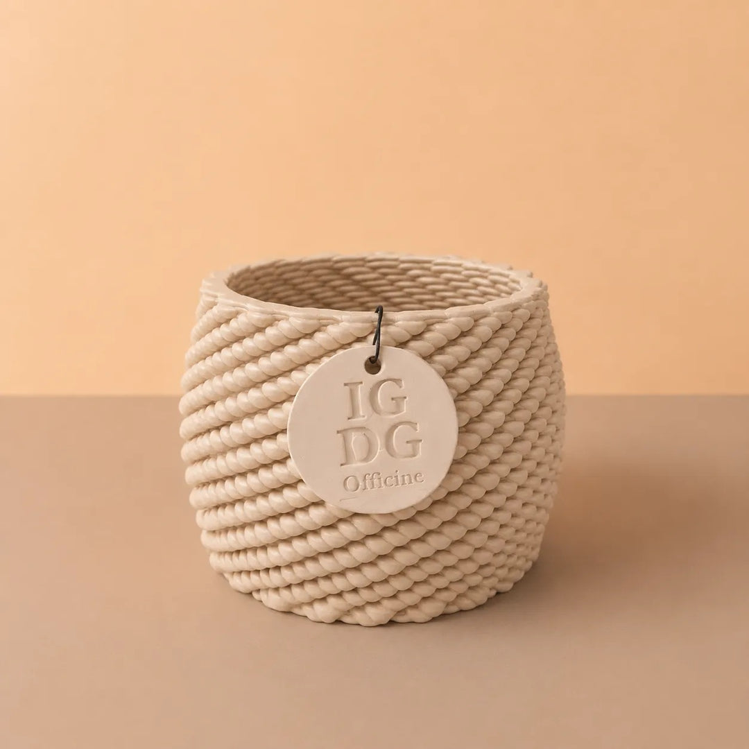 Vaso artigianale Carina in ceramica color avorio con caratteristica lavorazione intrecciata e targhetta identificativa, fotografato su sfondo neutro.