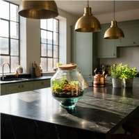 Terrarium Elia fittonia arancio su isola marmo nero in cucina loft con pendenti ottone e luce calda
