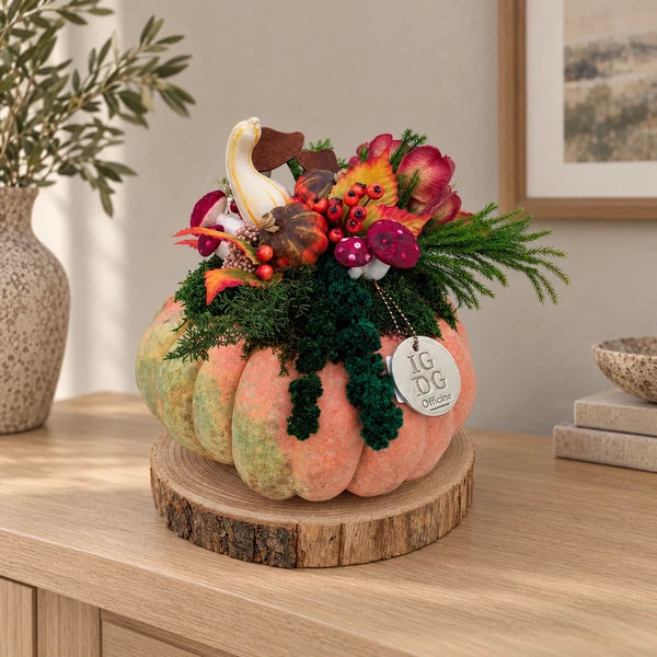 Zucca Grande con verde stabilizzato, decorazioni nei toni autunnali e base tonda in legno, su una consolle d’ingresso.